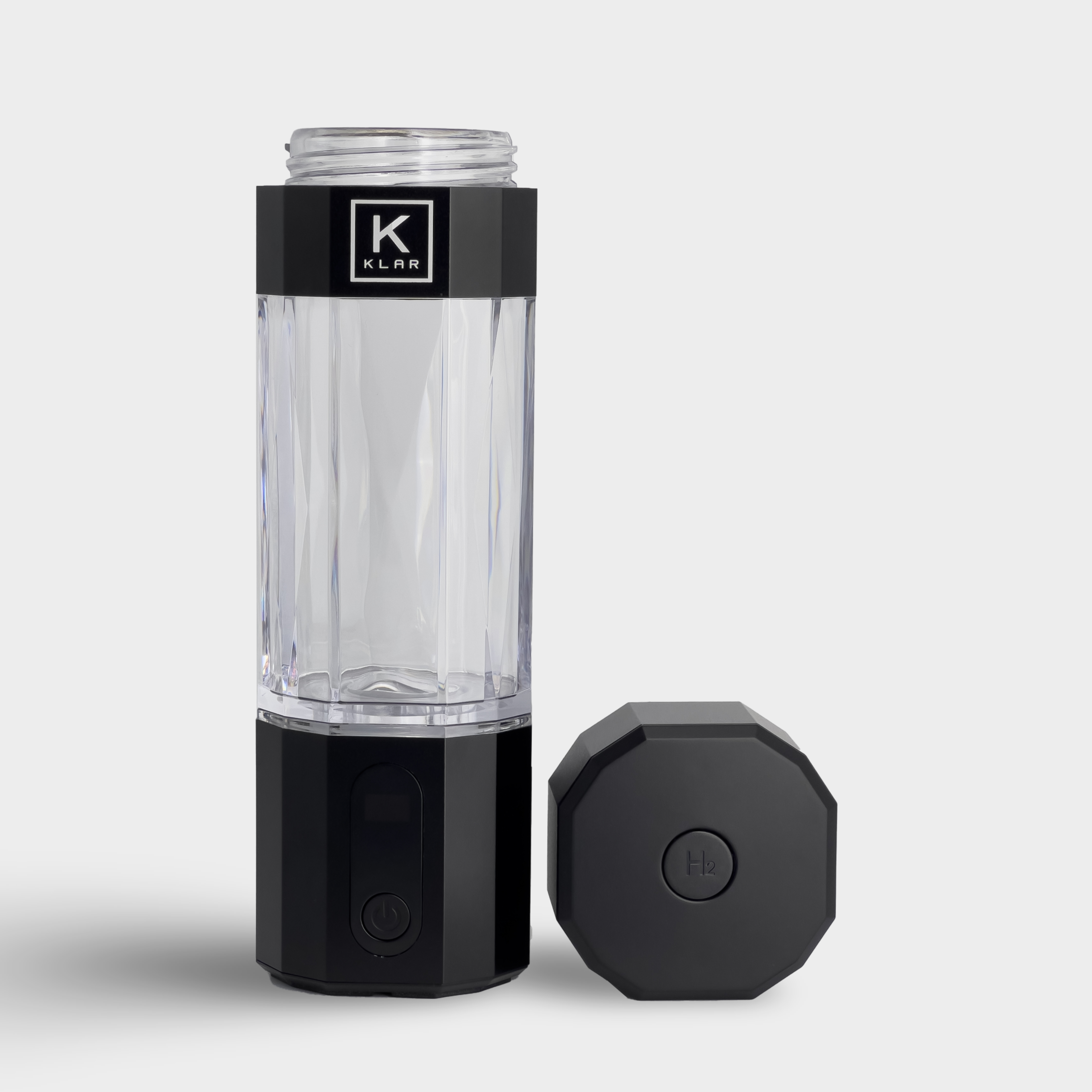 Front view of black KLAR ELITE hydrogen water bottle with lid, showcasing the pressure release valve on lid.